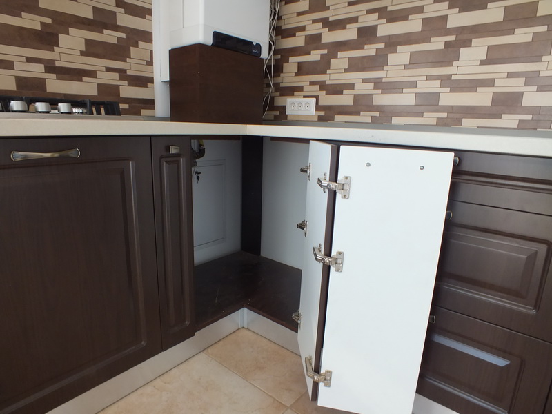 Особенность установки дверцы в угловой шкаф кухни. Применяются специальные петли.