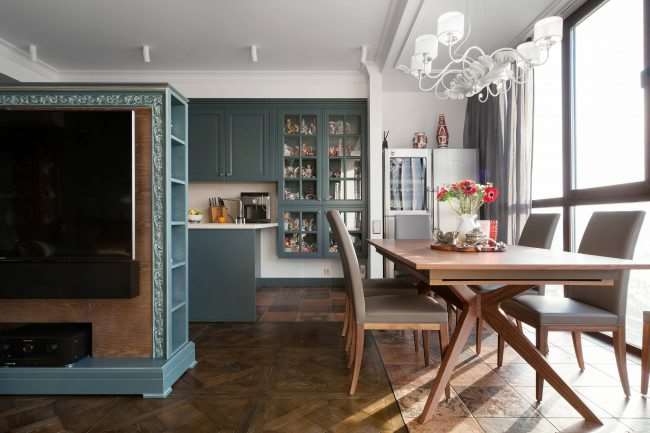 Пример сочетания близких цветов в рамочных фасадах классической кухни, собранной из модулей, и мебели в гостиной-студии